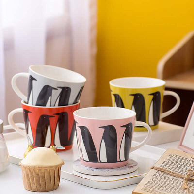 Super cute ceramic coffee mugs featuring penguin designs in pink, yellow, red, and white, perfect for couples.