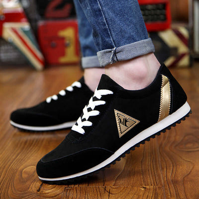 Stylish black sneakers with white laces and gold accents, perfect for casual wear.