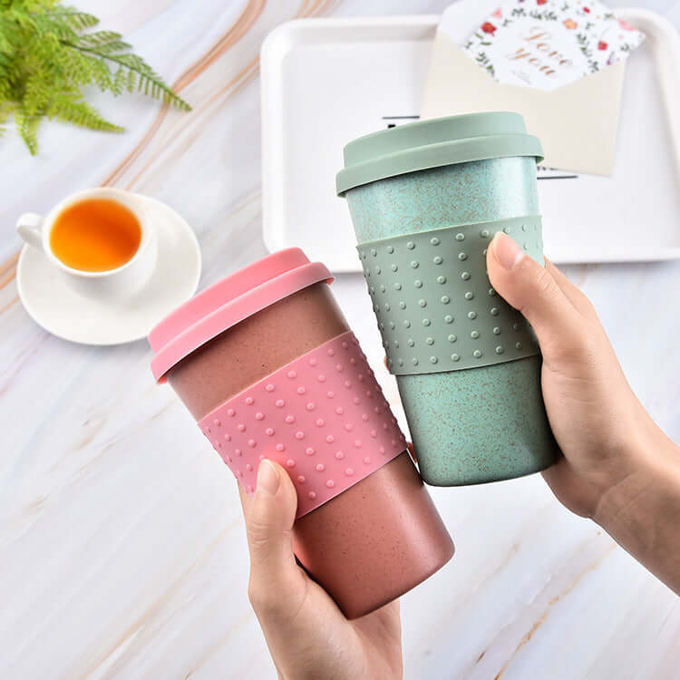 Two biodegradable wheat straw cups in pink and green colors, perfect for tea, coffee, or on-the-go use.