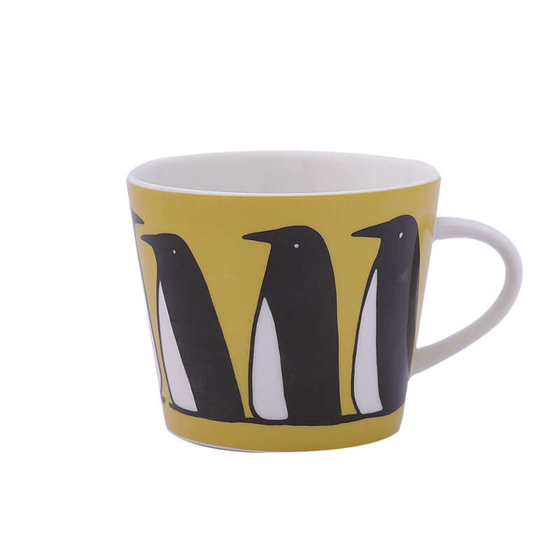 Ceramic coffee mug with penguin design on a yellow background, perfect for cozy mornings.