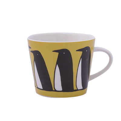 Ceramic coffee mug with penguin design on a yellow background, perfect for cozy mornings.