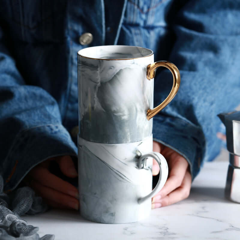 Stacked marble coffee mugs in ceramic with gold and white designs, ideal for 301-400ml beverages.