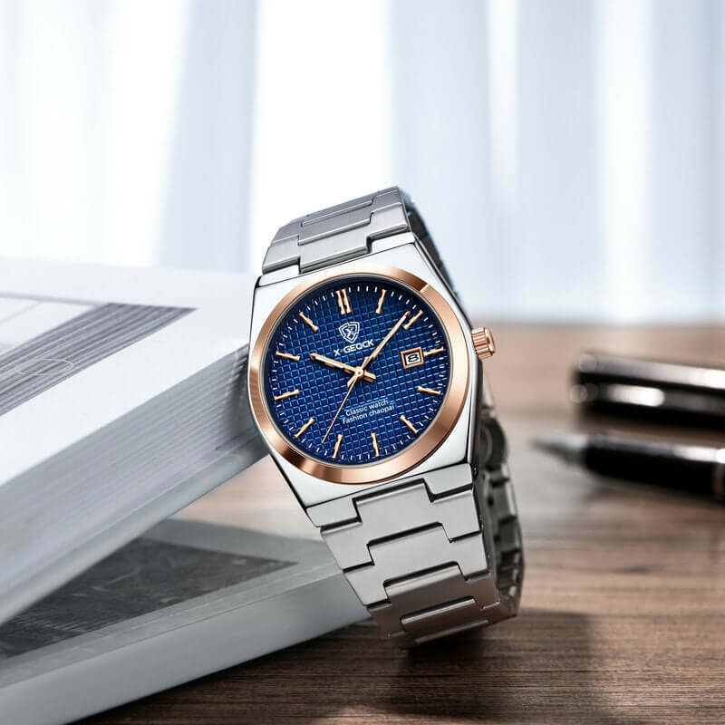 Men's quartz wrist watch with silver steel band and blue patterned dial by BONEHEAD PRO-CREATIONS on a desk.