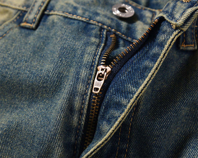 Close-up of dark blue denim jeans zipper showcasing quality craftsmanship for men's fashion work clothes.