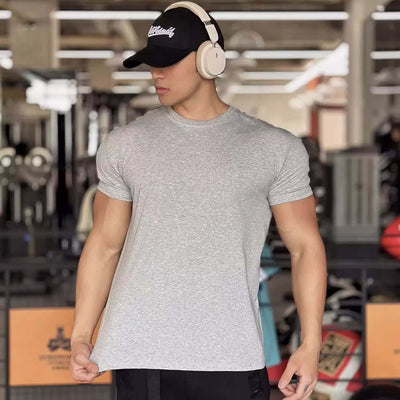 Men's slim fit grey short-sleeved sports t-shirt, ideal for summer fitness, shown in a gym setting.