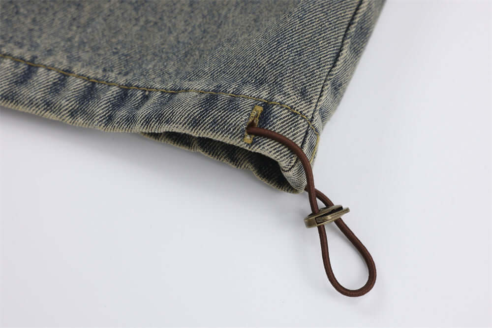 Close-up of vintage denim jeans fabric with drawstring detail, ideal for men's leisure wear.