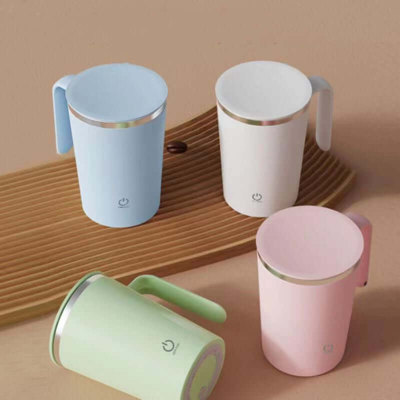 Colorful automatic stirring mugs in blue, white, pink, and green on a wooden surface for coffee or tea.