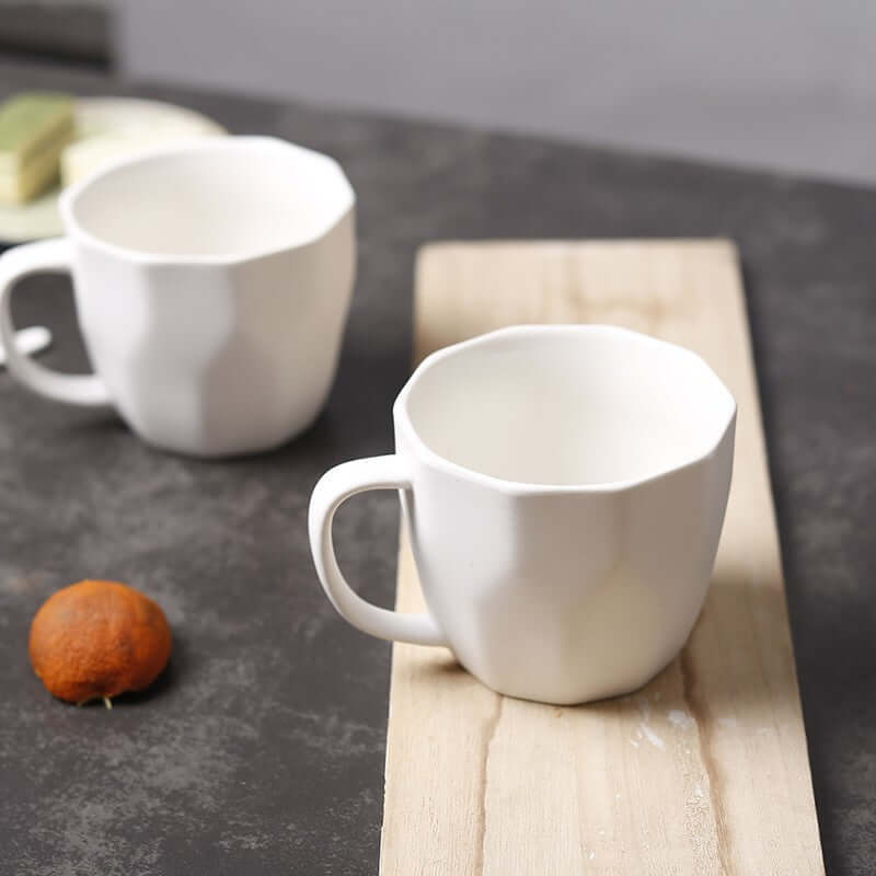 Diamond shaped ceramic mugs on a wooden surface, perfect for retro office use, modern and simple design.