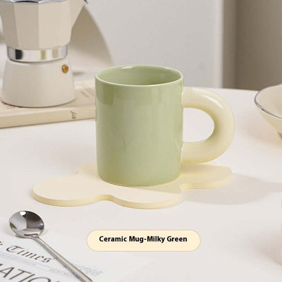 Milky green ceramic mug on a coaster, featuring a creative design and solid color, perfect for coffee or tea.