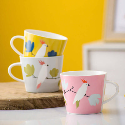 Super cute ceramic mugs with colorful bird designs in pink, white, and yellow, perfect for couples.