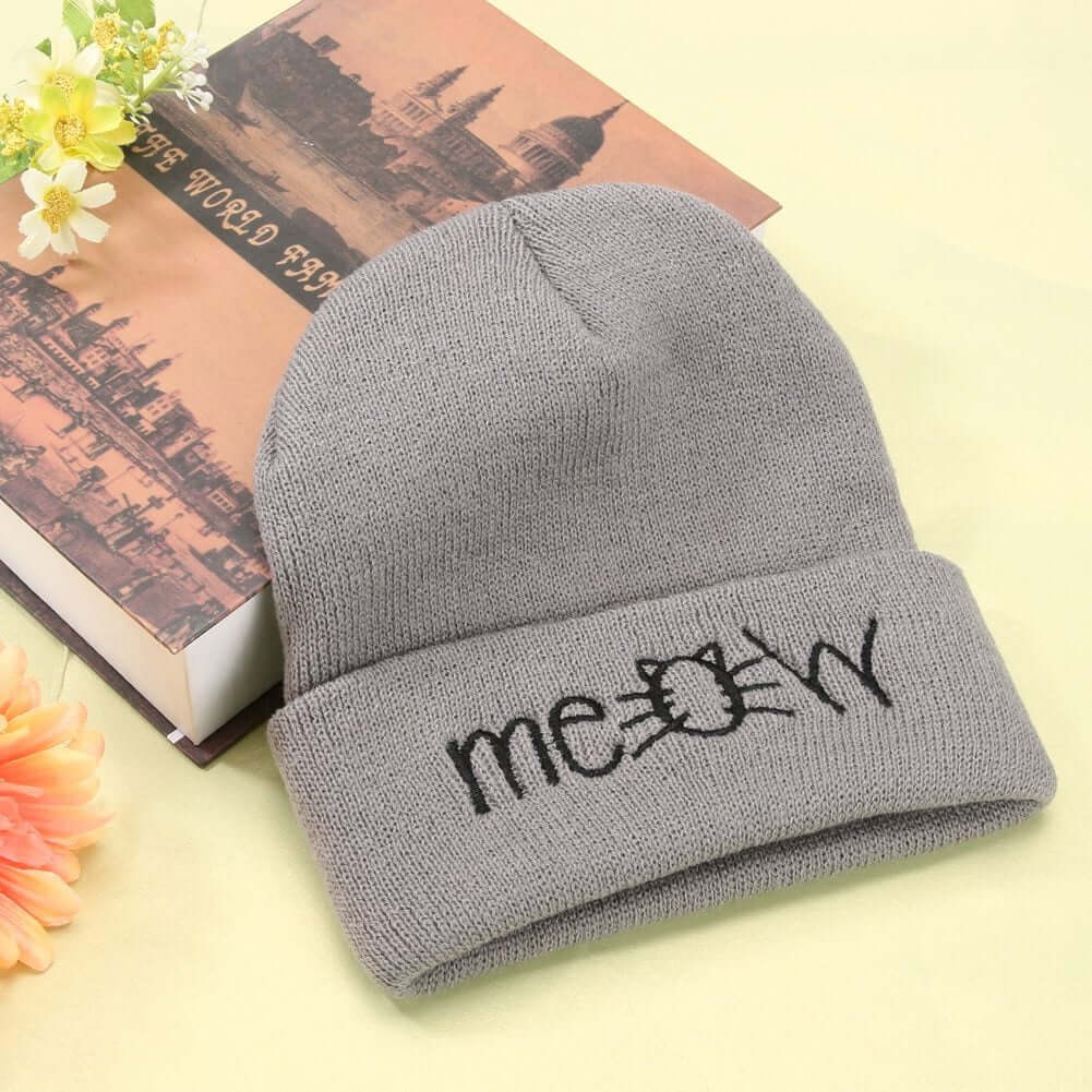 Gray knitted beanie hat with 'meow' embroidery, perfect for fall and winter casual wear.