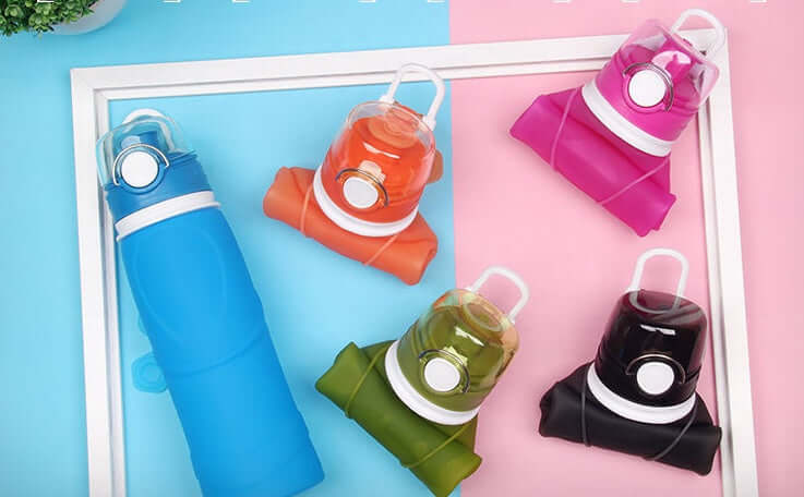 Colorful silicone folding water bottles in blue, orange, pink, green, and black on a bright background.