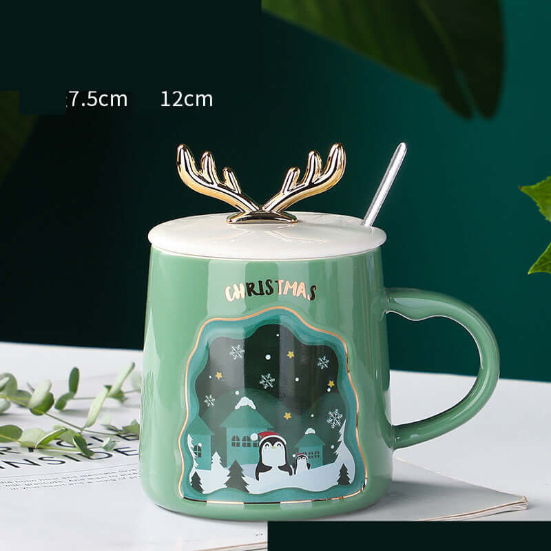 Ceramic Christmas mug with antler lid and spoon, featuring a festive penguin design, ideal for holiday coffee.