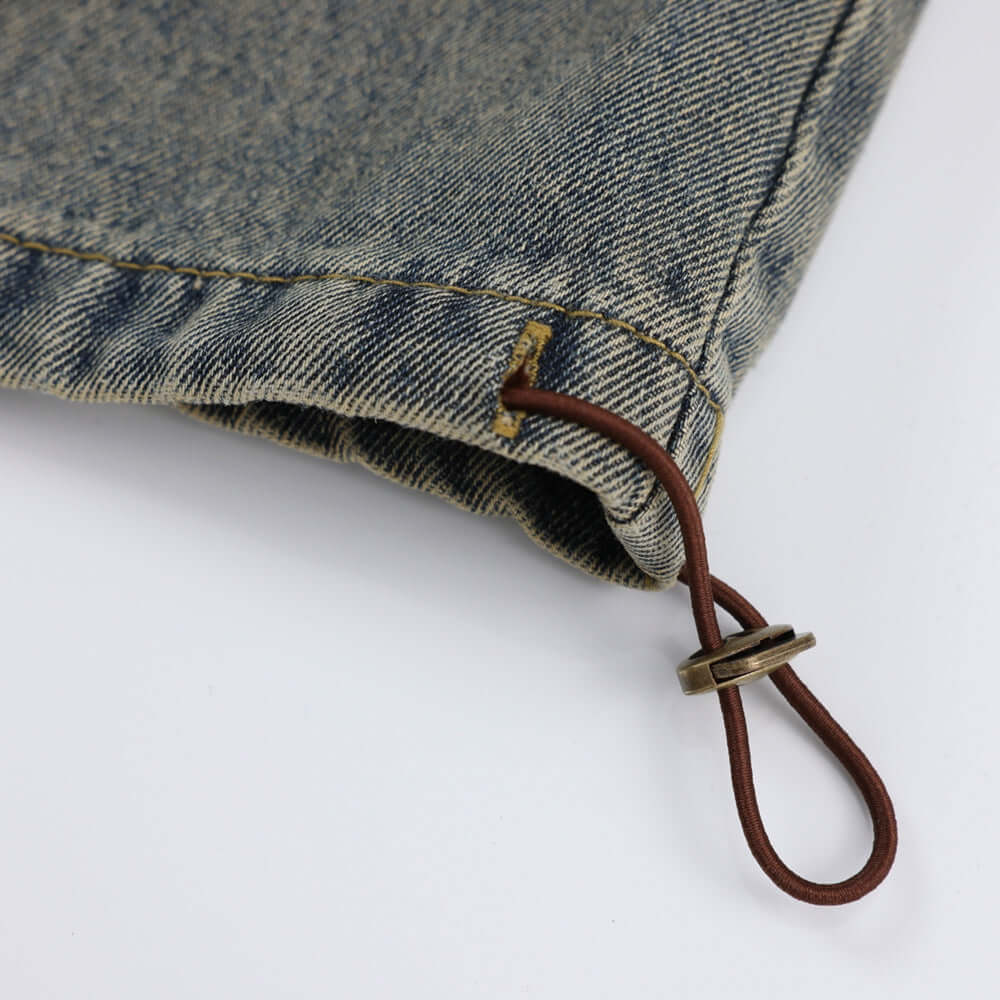 Close-up of vintage denim jeans detailing, showcasing the fabric texture and leather drawstring.