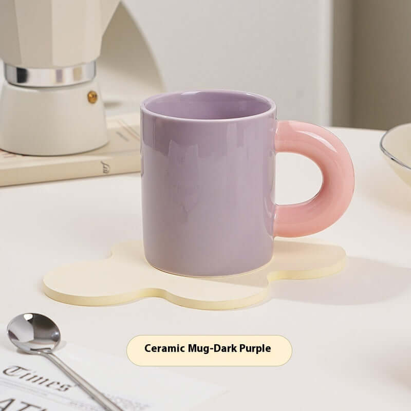 Beautiful ceramic mug in dark purple with a pink handle, perfect for stylish coffee or tea enjoyment.
