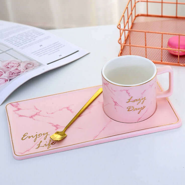 Pink marble grain ceramic coffee mug on stylish tray with gold spoon, perfect for office or home use.