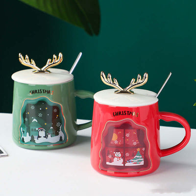 Set of Christmas mugs in green and red, featuring antler lids and winter designs, perfect for holiday beverages.