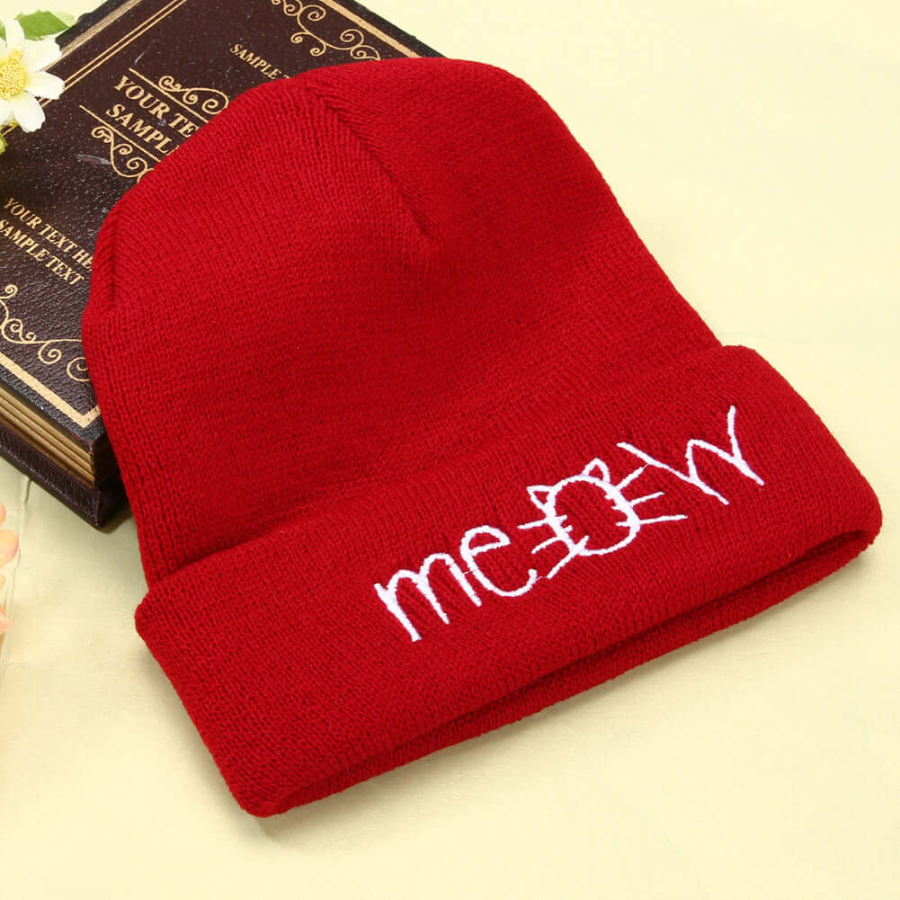 Red knitted beanie hat with 'meow' embroidery, casual winter accessory for men and women by BONEHEAD PRO-CREATIONS.