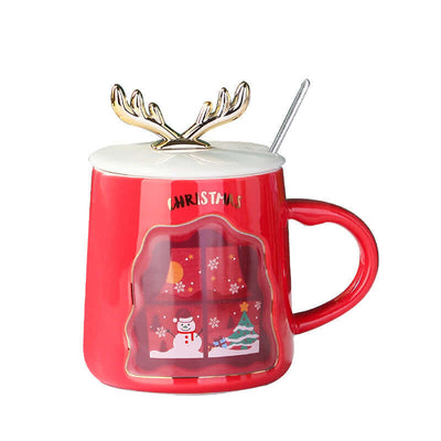 Red ceramic Christmas mug with antlers and spoon, featuring festive winter scene design.