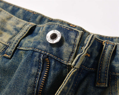 Close-up of men's dark blue denim jeans showing the top button and zipper detail for fashion work clothes.