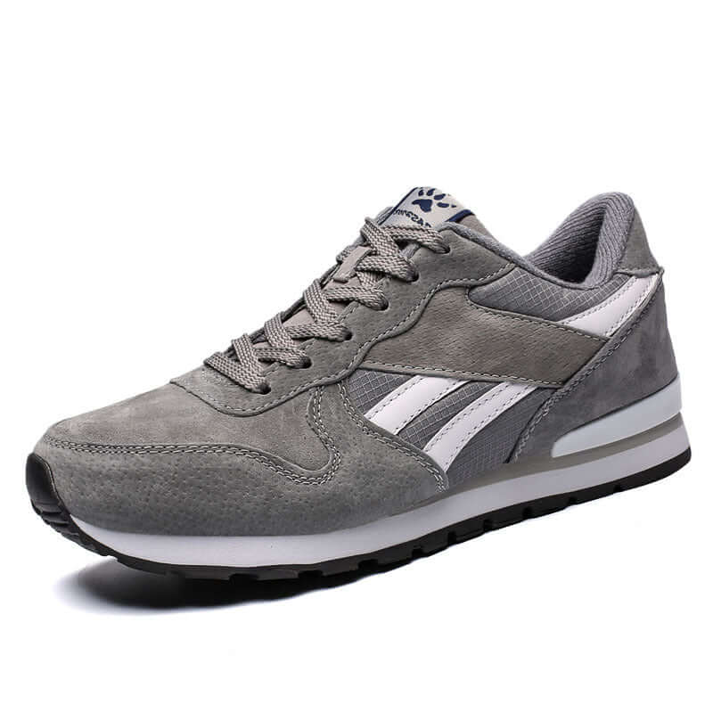Gray casual running shoes with white stripes, ideal for men, featuring a stylish low upper and comfortable sole.
